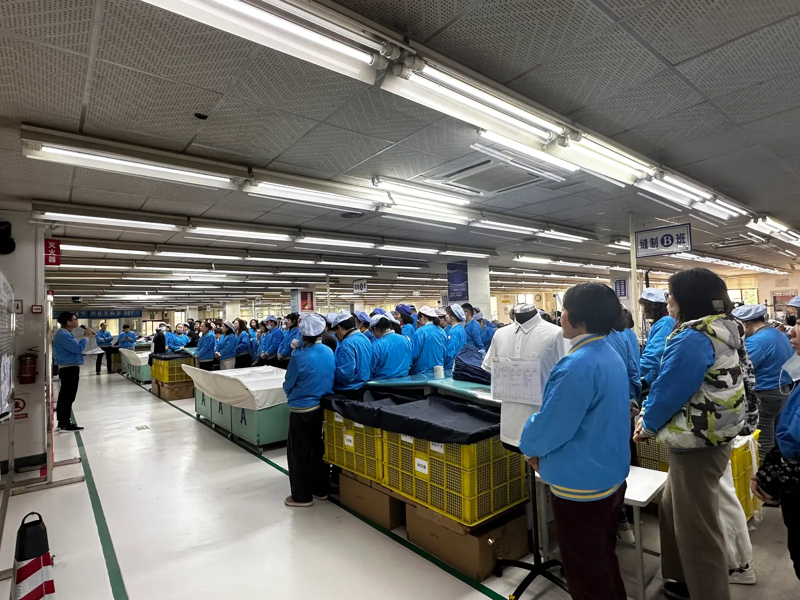 Workers gathered for a briefing on a factory floor