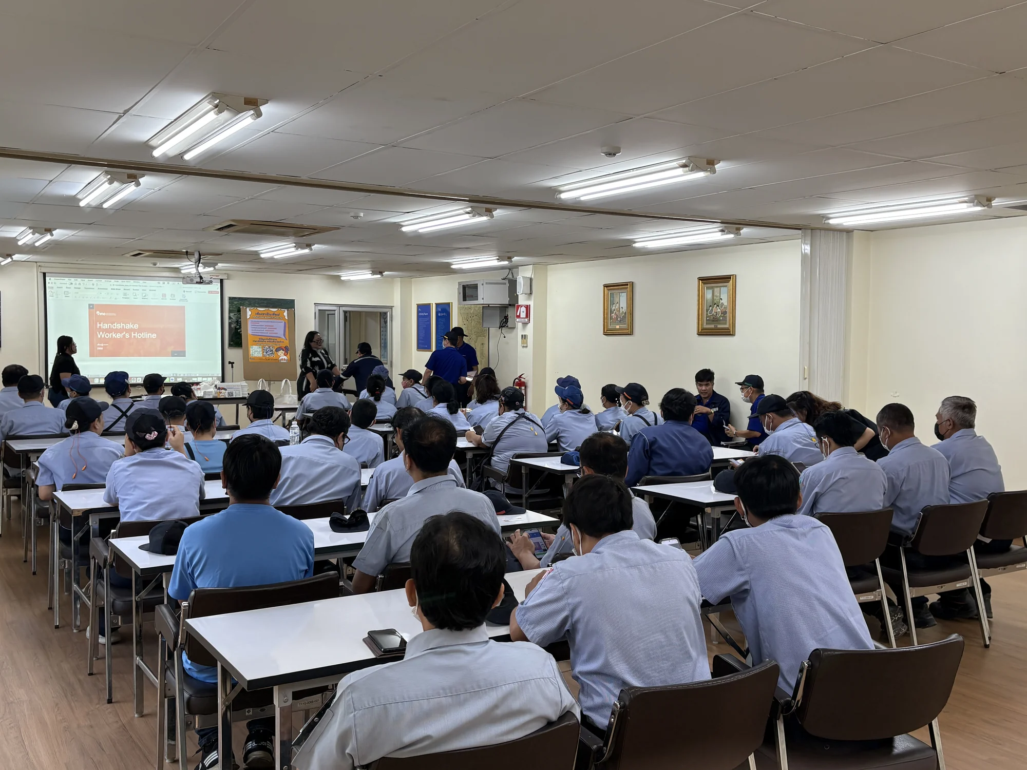 Workers attending a workplace session in a factory meeting room
